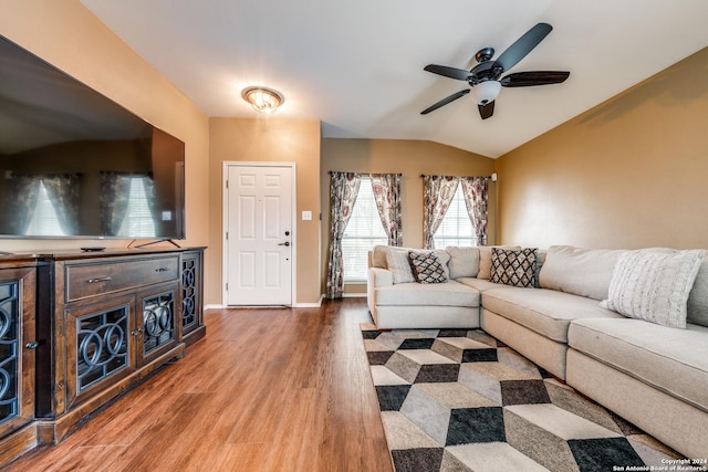 living room with ceiling fan, hardwood / wood-style floors, and vaulted ceiling