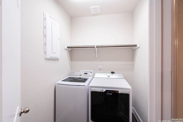 laundry room featuring electric panel and separate washer and dryer