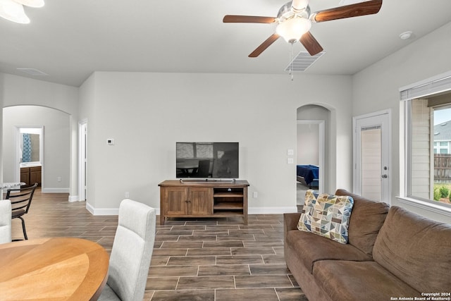 living room featuring ceiling fan and dark hardwood / wood-style floors