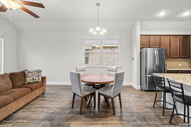 dining area featuring ceiling fan with notable chandelier and dark wood-type flooring