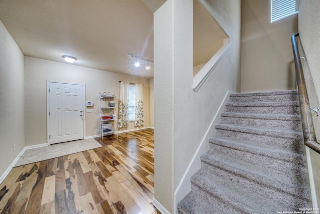 foyer entrance featuring hardwood / wood-style floors and a textured ceiling