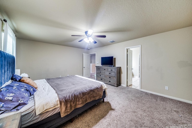 carpeted bedroom with connected bathroom, ceiling fan, and a textured ceiling