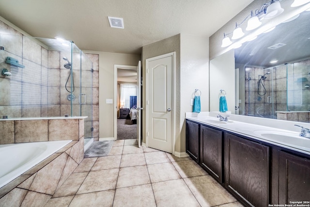 bathroom with tile patterned flooring, vanity, a textured ceiling, and independent shower and bath