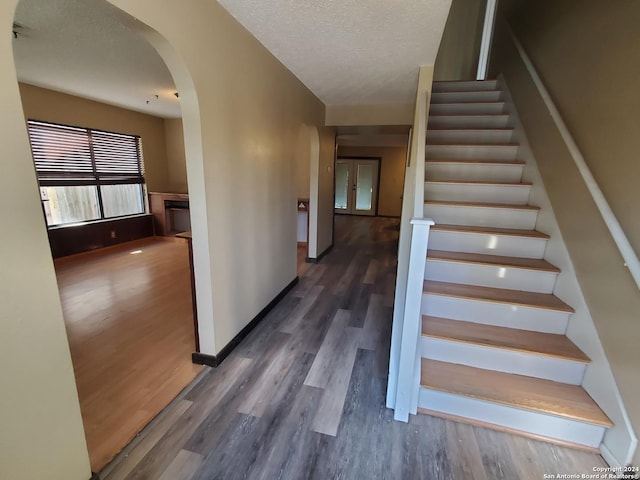 stairway featuring wood-type flooring and a textured ceiling