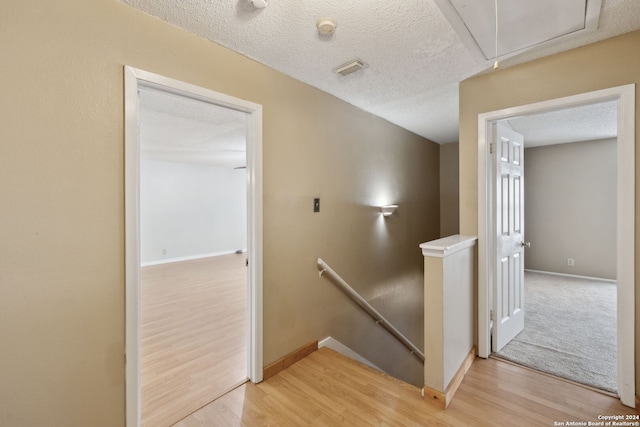 staircase featuring hardwood / wood-style flooring and a textured ceiling