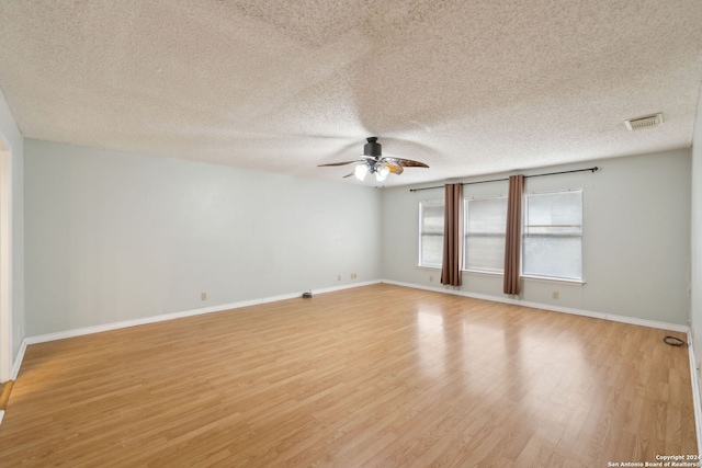 empty room with ceiling fan, a textured ceiling, and light hardwood / wood-style flooring