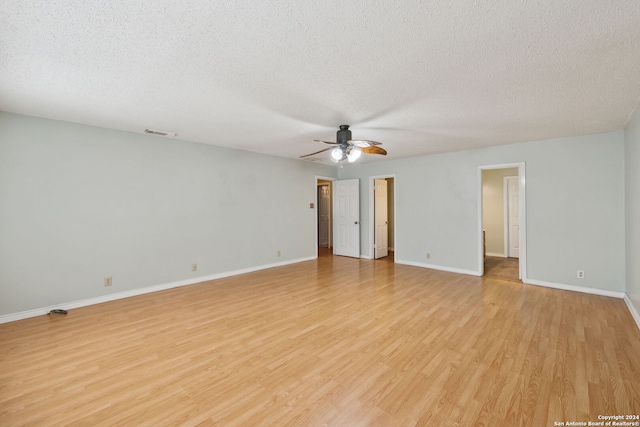 empty room with ceiling fan, a textured ceiling, and light hardwood / wood-style floors