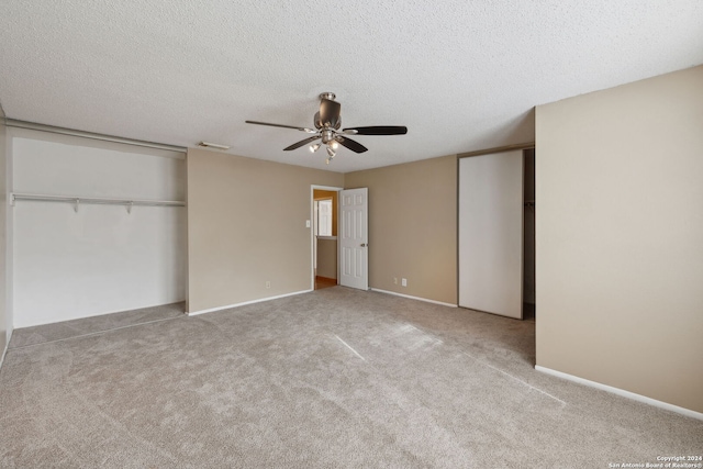 unfurnished bedroom with light carpet, a textured ceiling, and ceiling fan