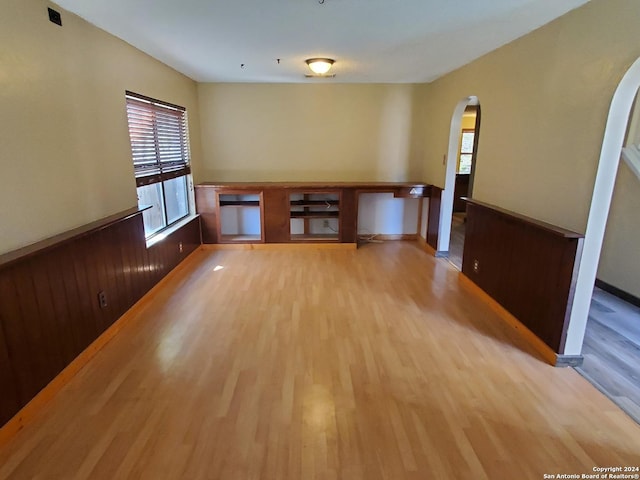 spare room with hardwood / wood-style floors and wood walls