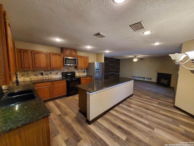 kitchen with sink, ceiling fan, stainless steel appliances, wood-type flooring, and decorative backsplash