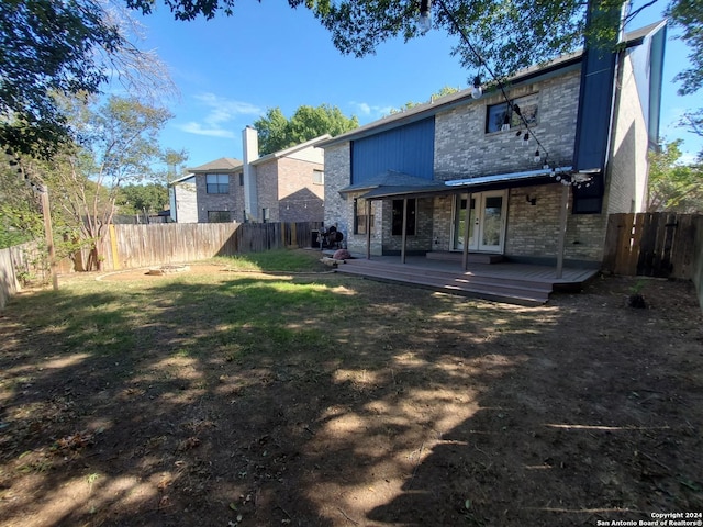 rear view of property with a deck and a lawn