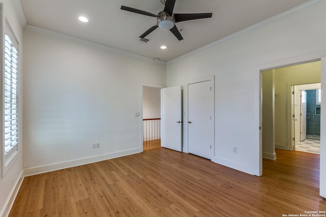 unfurnished bedroom featuring hardwood / wood-style floors, crown molding, and multiple windows