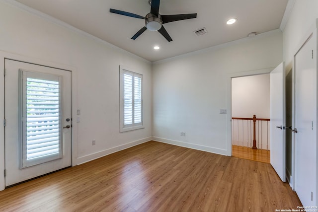 unfurnished room with crown molding, plenty of natural light, ceiling fan, and light hardwood / wood-style flooring