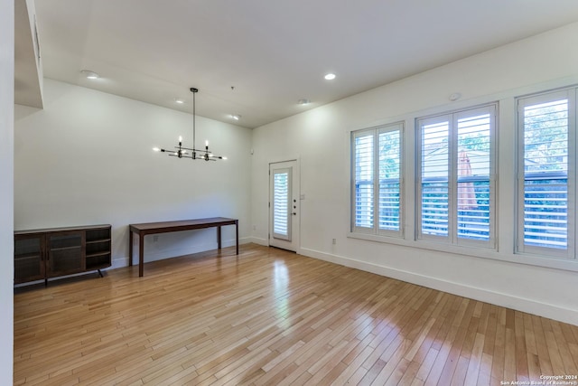 foyer entrance with a notable chandelier and light wood-type flooring