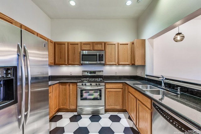 kitchen featuring sink, stainless steel appliances, and dark stone counters