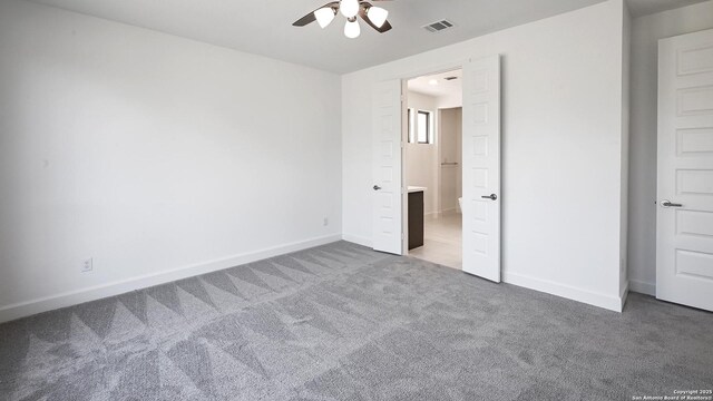 unfurnished bedroom with carpet floors, baseboards, visible vents, and ceiling fan