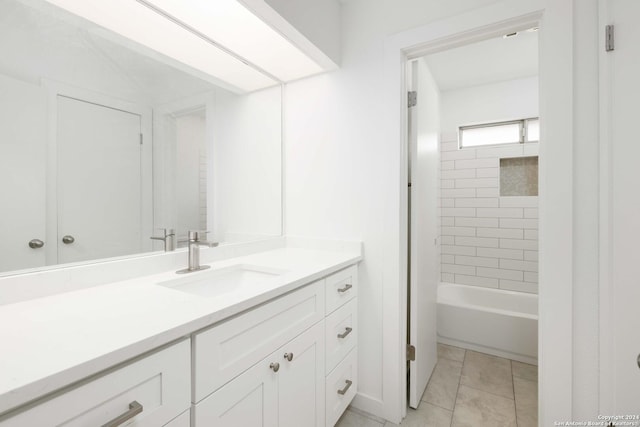 bathroom featuring tile patterned flooring, vanity, and tiled shower / bath