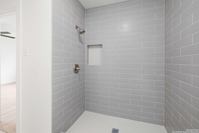 bathroom featuring tiled shower and ceiling fan