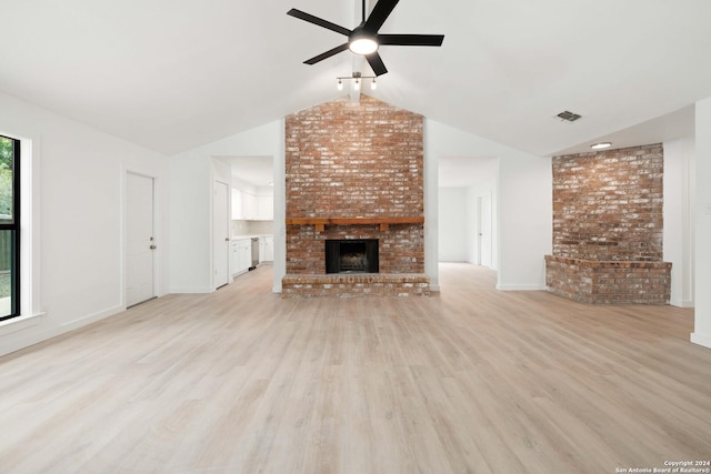 unfurnished living room with light wood-type flooring, a brick fireplace, brick wall, ceiling fan, and lofted ceiling