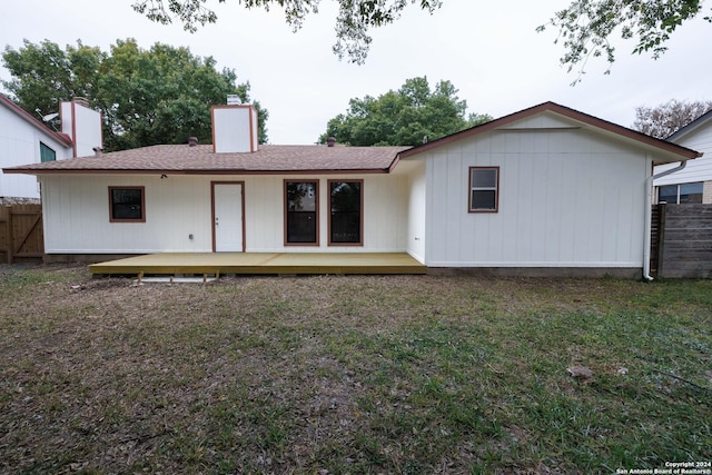 back of property featuring a lawn and a deck