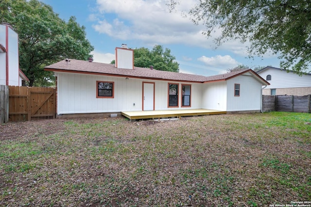 rear view of house with a yard and a deck