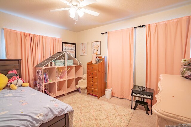 carpeted bedroom with ceiling fan and a textured ceiling