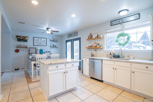 kitchen with white cabinets, a wealth of natural light, dishwasher, and a kitchen island