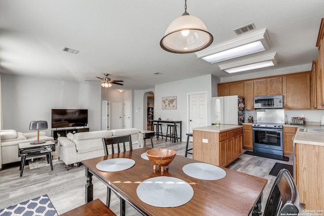 dining area featuring light hardwood / wood-style flooring, ceiling fan, and sink