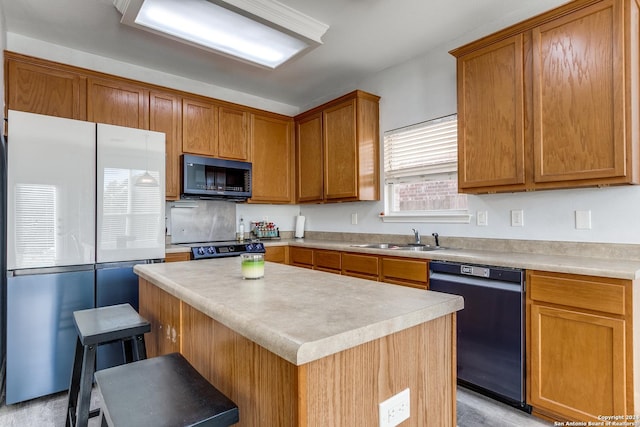 kitchen with a center island, sink, a breakfast bar, black appliances, and light wood-type flooring