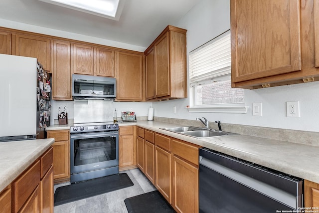 kitchen featuring appliances with stainless steel finishes, light hardwood / wood-style flooring, and sink