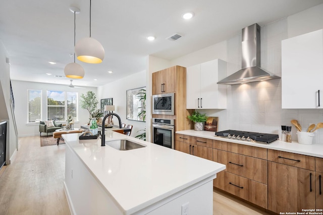719 E Locust St Unit 2103, San Antonio, TX 78212 - kitchen featuring wall chimney range hood, stainless steel appliances, a sink, decorative backsplash, and modern cabinets