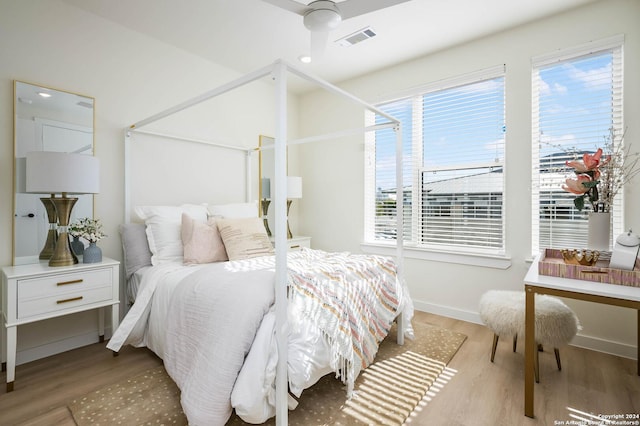 bedroom featuring multiple windows, ceiling fan, and light hardwood / wood-style flooring