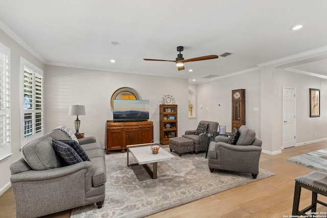 living room with light hardwood / wood-style flooring, ceiling fan, and ornamental molding