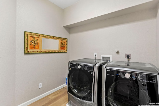 laundry area with separate washer and dryer and light hardwood / wood-style flooring