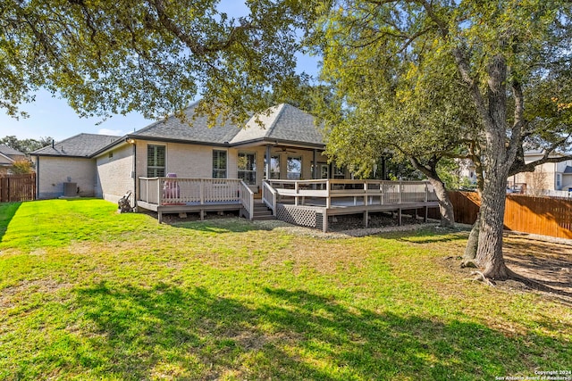 rear view of house with ceiling fan, a yard, cooling unit, and a deck