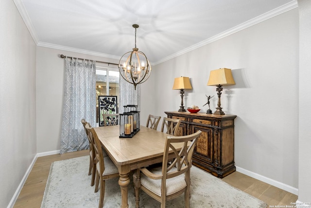 dining space featuring light hardwood / wood-style floors, an inviting chandelier, and crown molding