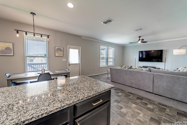 kitchen featuring light stone countertops, ceiling fan, pendant lighting, and a wall mounted air conditioner