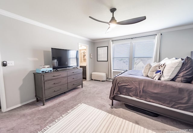 carpeted bedroom with ensuite bath, ceiling fan, and ornamental molding