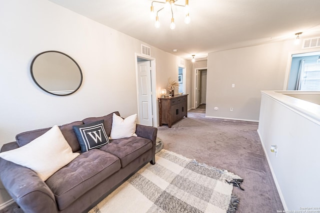 carpeted living room with an inviting chandelier