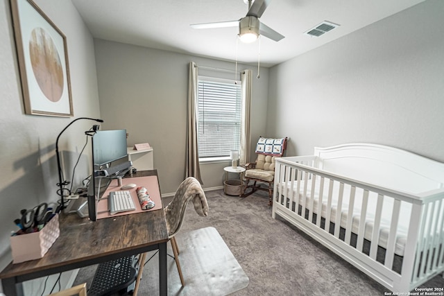 carpeted bedroom featuring ceiling fan and a nursery area