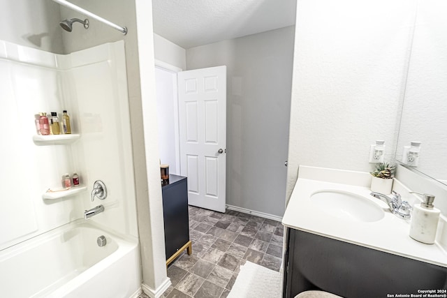 bathroom featuring bathtub / shower combination, a textured ceiling, and vanity