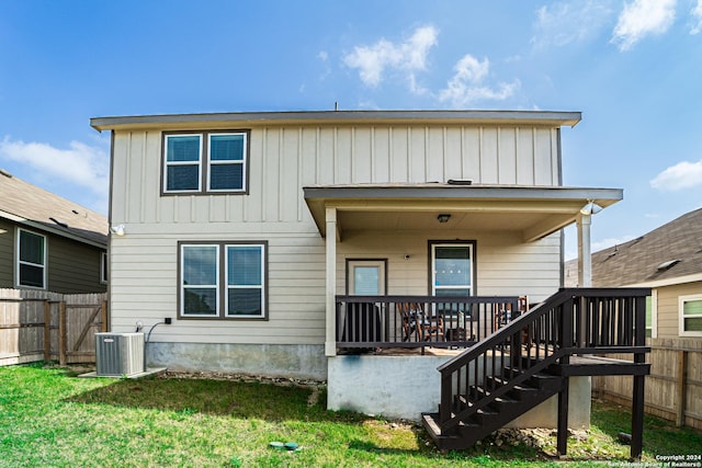 rear view of property featuring a yard and cooling unit