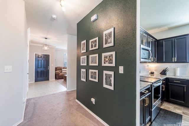 kitchen featuring stainless steel appliances, light stone counters, backsplash, light carpet, and ornamental molding