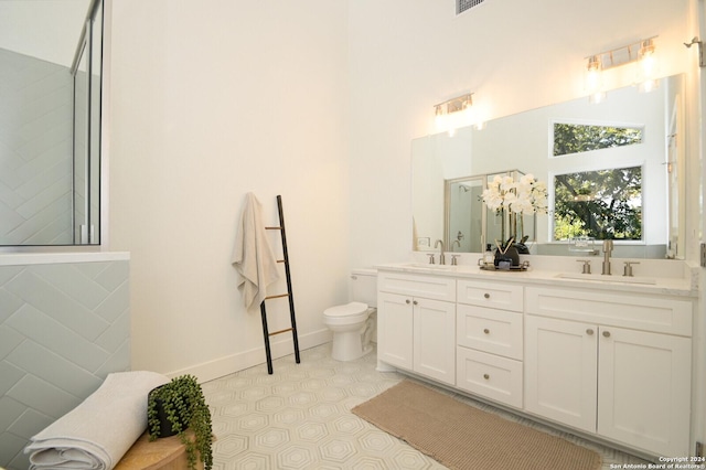 bathroom with a shower, tile patterned floors, vanity, and toilet