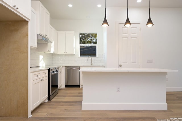 kitchen featuring a center island, white cabinets, stainless steel appliances, and light hardwood / wood-style floors