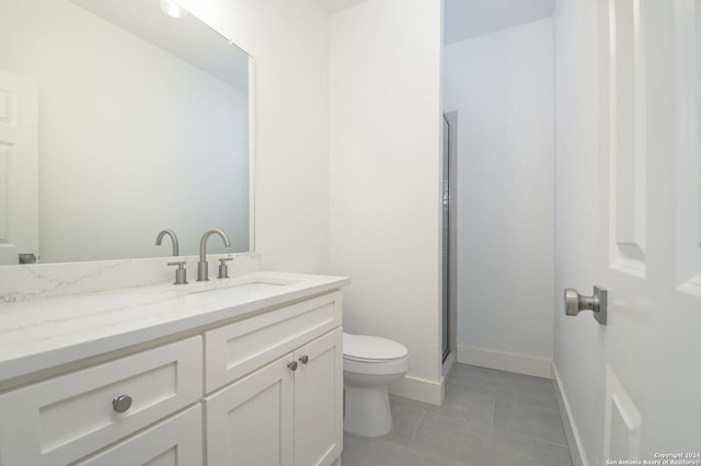 bathroom featuring tile patterned flooring, vanity, an enclosed shower, and toilet