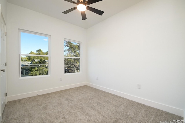 carpeted empty room featuring ceiling fan and lofted ceiling