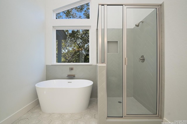 bathroom with separate shower and tub, tile patterned floors, and vaulted ceiling