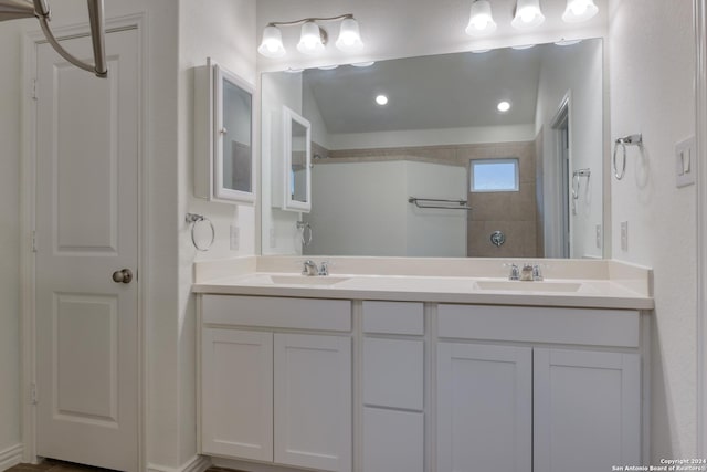 bathroom featuring a tile shower and vanity