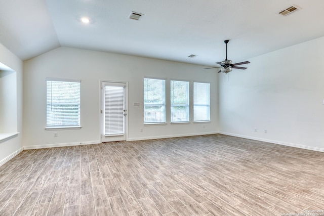 unfurnished living room with a healthy amount of sunlight, ceiling fan, light hardwood / wood-style floors, and vaulted ceiling